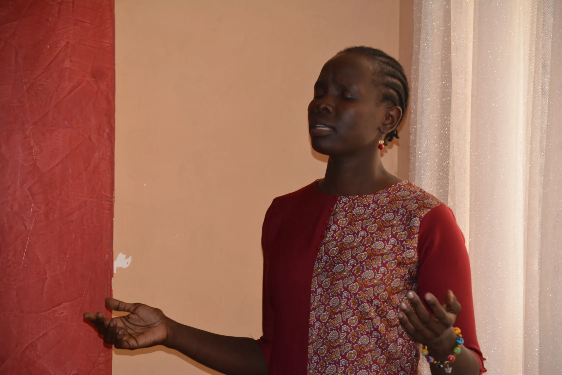 A worshipper lifts her hands at Hanamel Gospel Ministries